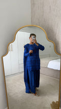Model wearing a royal blue Farah shalwar with intricate detailing, reflected in a mirror, showcasing elegance and comfort.