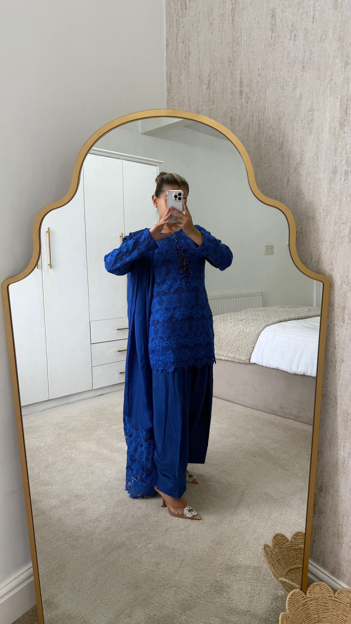 Model wearing a royal blue Farah shalwar with intricate lace detailing, standing in front of a mirror.